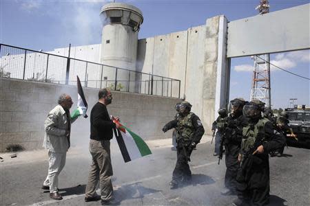 Protesters stand in front of Israeli policemen officers during a protest calling for the release of Palestinian prisoners held in Israeli jails, near an Israeli checkpoint in the West Bank town of Bethlehem April 4, 2014. REUTERS/Ammar Awad