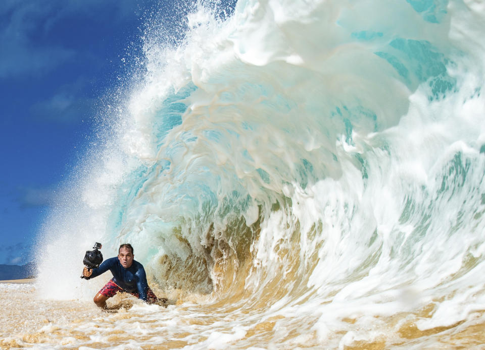 CORRECTS SPELLING OF PHOTOGRAPHER'S FIRST NAME TO JERRETT - In this undated photo provided by Jerrett Lau, Clark Little photographs waves on the North Shore of Oahu near Haleiwa, Hawaii. (Jerrett Lau via AP)