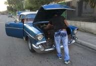 A man repairs a 1957 Chevrolet car on a street in Havana December 23, 2014. REUTERS/Stringer