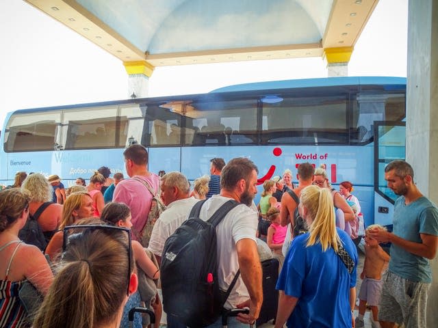 Evacuees wait to get on buses as they leave their hotel during a forest fire on the island of Rhodes on Sunday