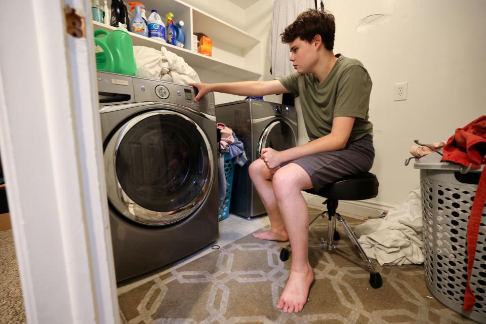 Connor Campbell, 16, partakes in one of his favorite activities, watching the laundry machine run at home in Provo on Sunday, May 28, 2023. Connor is autistic, nonverbal and has epilepsy. He lives at the Utah State Developmental Center in American Fork but comes home on Sundays, and can spend hours watching the laundry. | Kristin Murphy, Deseret News