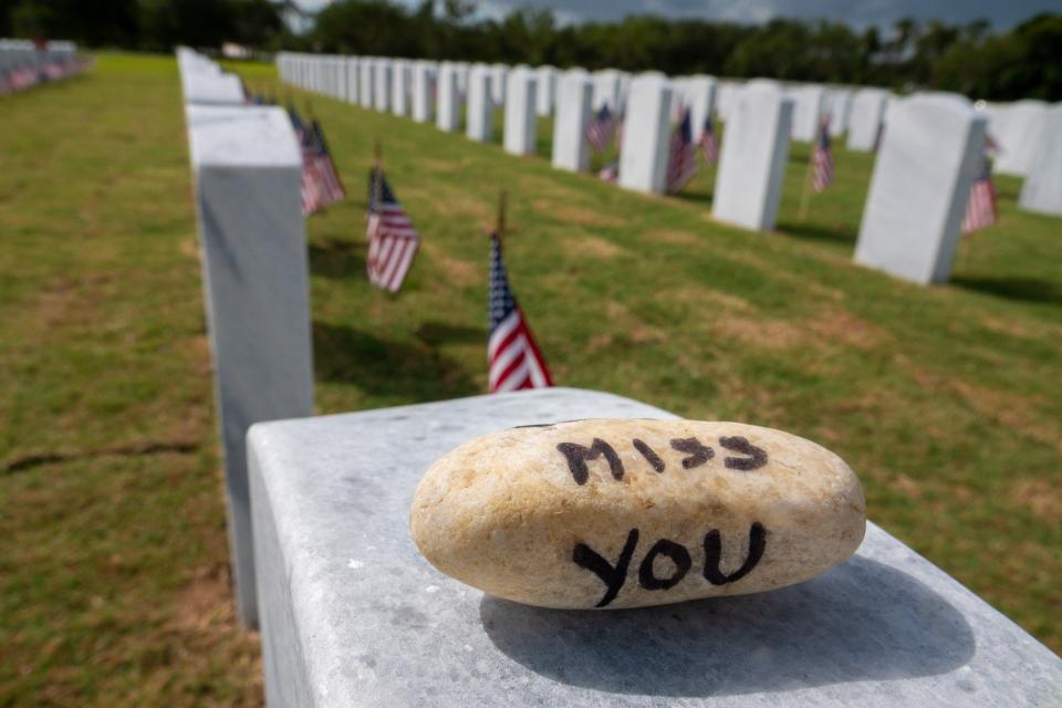 Visitors leave messages before a Memorial Day ceremony at the South Florida National Cemetery in Lake Worth, Florida on May 31, 2021.   RICHARD GRAULICH/PALM BEACH POST