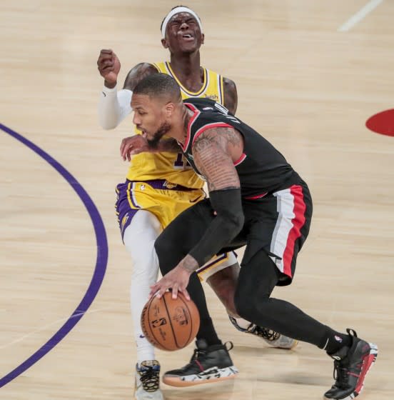 Lakers guard Dennis Schroder fouls Trail Blazers guard Damian Lillard as he drives during a game at Staples Center.