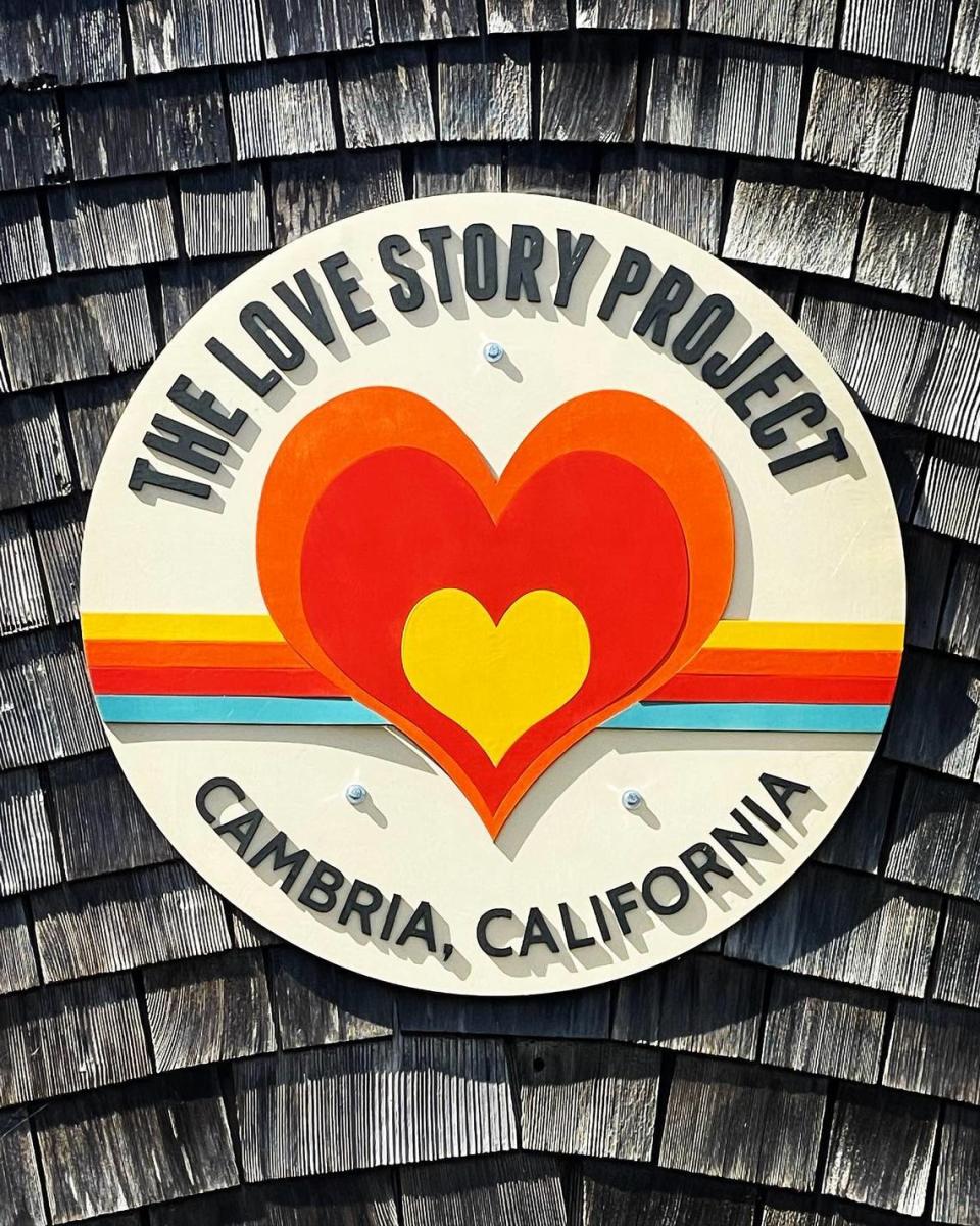 This large button-shaped sign lets people know where The Love Story Project’s new, larger location is, a half block away from the space it occupied for eight years.