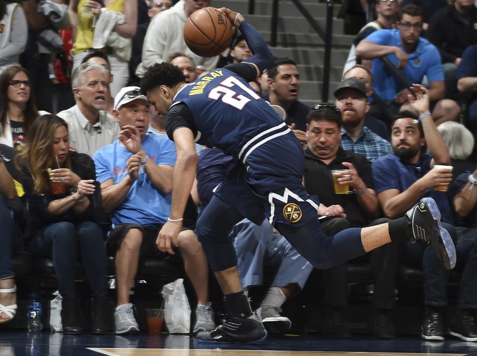 Denver Nuggets guard Jamal Murray dives into the fans in the courtside seats to save a loose ball in the first half of Game 7 of an NBA basketball second-round playoff series against the Portland Trail Blazers Sunday, May 12, 2019, in Denver. (AP Photo/John Leyba)