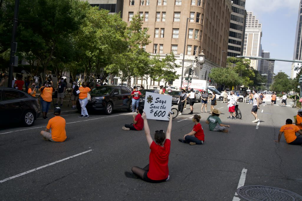 Protestors hold signs and sit in the middle of Poydras Street in New Orleans outside U.S. Sen. John Kennedy's office