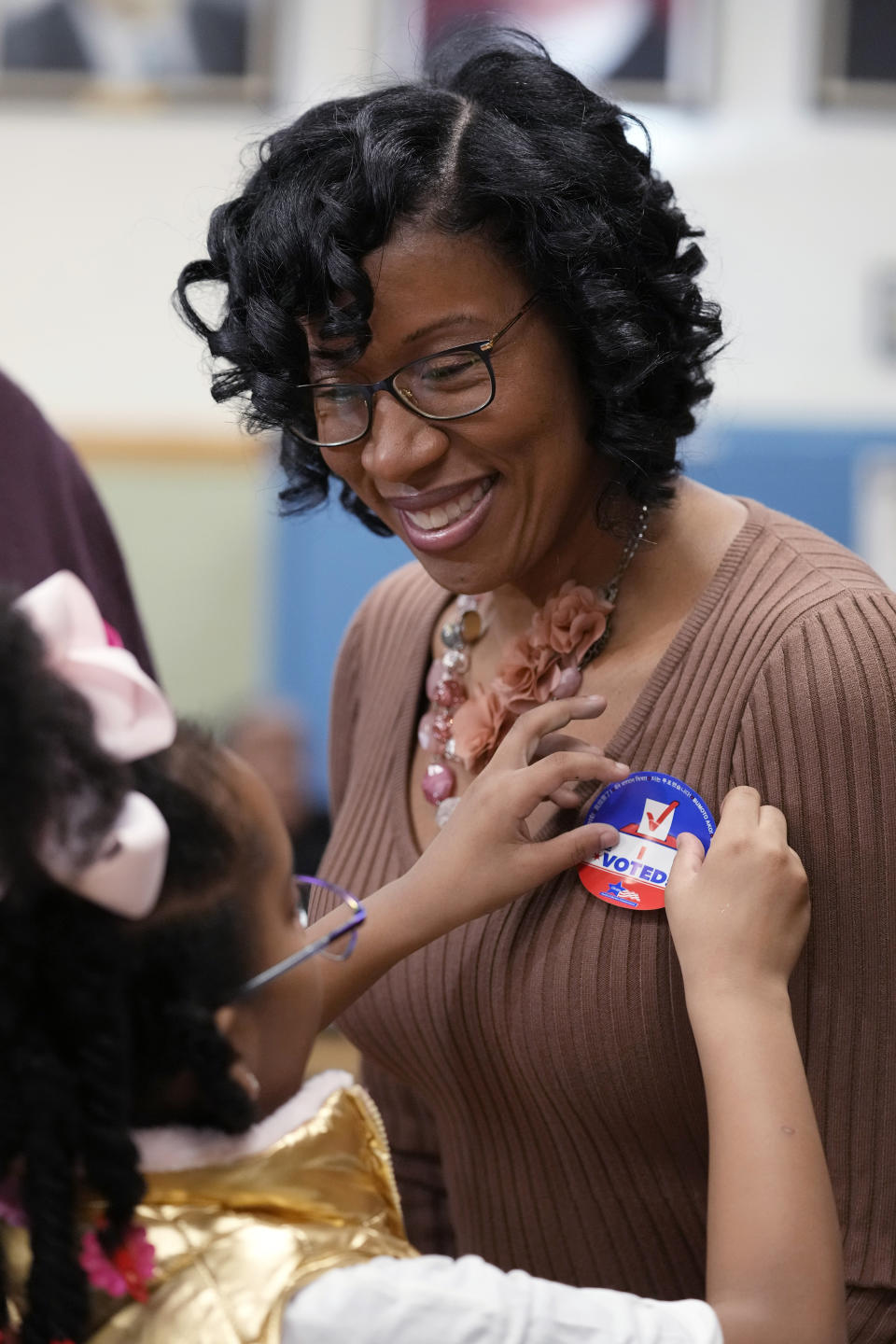 Chicago Treasurer Melissa Conyears-Ervin who runs for Congress in the 7th District, gets a "I voted" sticker from her daughter Jeneva after voting at Marshall Metro high school in Chicago, Tuesday, March 19, 2024. Illinois residents will vote Tuesday to narrow Democratic and GOP candidate fields in key U.S. House races. (AP Photo/Nam Y. Huh)