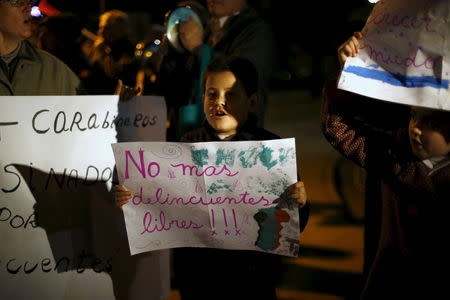 A child holds up a placard that reads "No more free delinquents!" during a rally against what rally participants say is an explosion in crime, Santiago, Chile, July 29, 2015. REUTERS/Ivan Alvarado