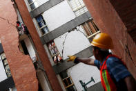 A worker points at damaged apartments after the earthquake, in the Narrate neighborhood in Mexico City, Mexico September 27, 2017. REUTERS/ Carlos Jasso