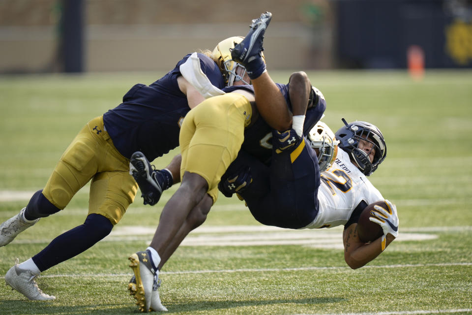 Toledo running back Bryant Koback (22) gets tackled by Notre Dame defenders in the second half of an NCAA college football game in South Bend, Ind., Saturday, Sept. 11, 2021. Notre Dame won 32-29. (AP Photo/AJ Mast)