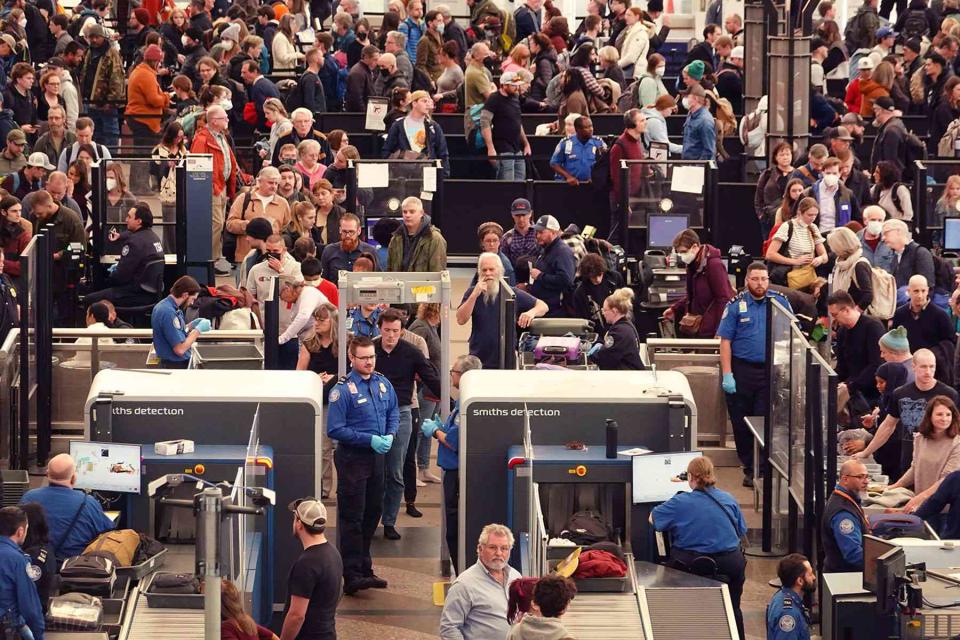 <p>Scott Olson/Getty Images</p> Travelers navigate a security checkpoint at Denver International Airport on November 22, 2022 in Denver, Colorado.