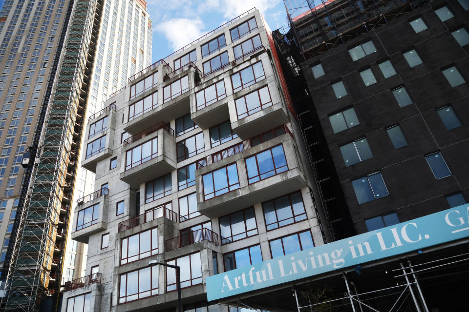 A sign promotes a new apartment building located in Long Island City near the site for a proposed Amazon headquarters in the Queens borough of New York, Friday, Nov. 16, 2018. City and state officials promised at least $2.8 billion in tax credits and grants to lure Amazon to Queens, where it would occupy a new campus built around a formerly industrial boat basin. (AP Photo/Mark Lennihan)