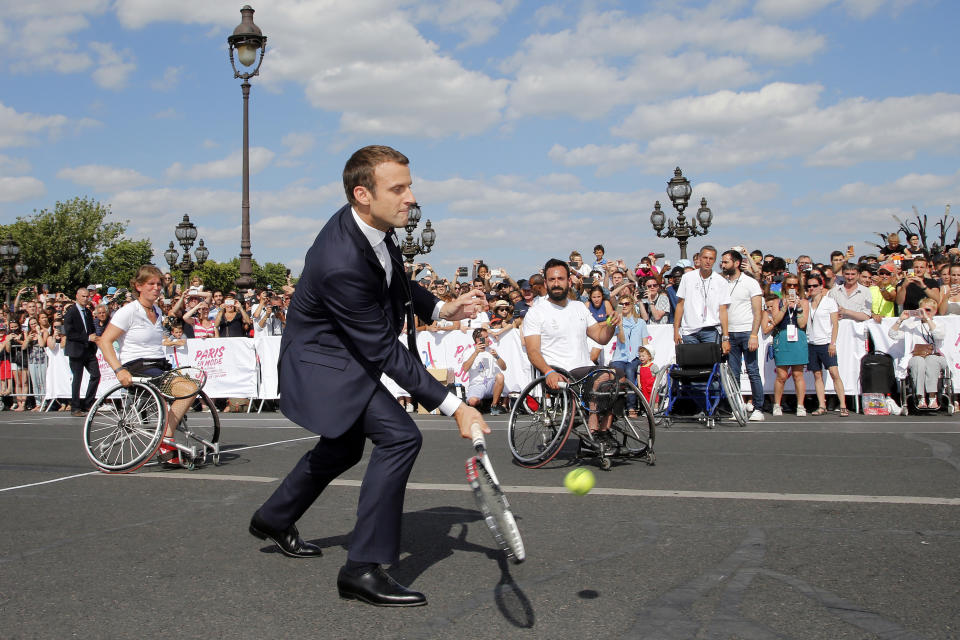 FILE - French President Emmanuel Macron plays tennis on the Pont Alexandre III in Paris, France, June 24, 2017 to celebrate International Olympic Days. (Jean Paul Pelissier, Pool Photo via AP, File)