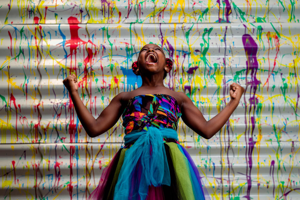 Marian Scott is pictured yelling into the air while wearing a colourful dress. Source: https: Jermaine Horton