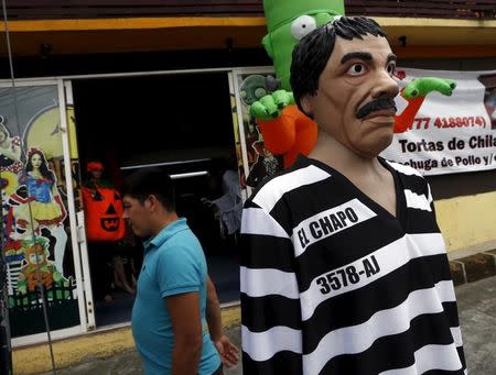 A man walks past a Guzman costume on display at the front of a shop, in the Mexican city of Cuernavaca near Mexico City October 14, 2015. REUTERS/Henry Romero