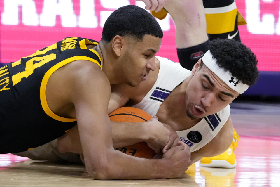 Iowa forward Kris Murray, left, and Northwestern forward Tydus Verhoeven battle for the ball during the first half of an NCAA college basketball game in Evanston, Ill., Sunday, Feb. 19, 2023. (AP Photo/Nam Y. Huh)