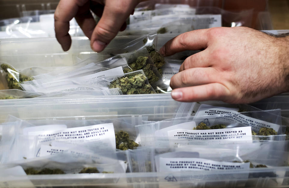 FILE - In this Jan. 6, 2018, file photo, an employee stocks cannabis at a store shortly before its first day of recreational marijuana sales in San Francisco. California has endorsed a rule that will allow home marijuana deliveries statewide, even into communities that have banned commercial pot sales. The rule finalized Wednesday, Jan. 16, 2019, by state officials was opposed by police chiefs and other critics who say it will create an unruly market of largely hidden pot transactions and encourage potential criminal activity. (AP Photo/Noah Berger, File)