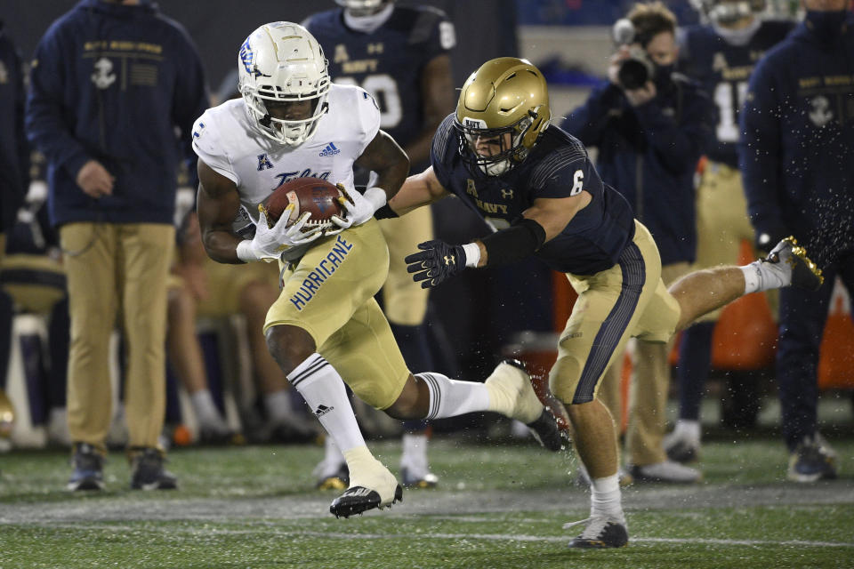 Tulsa wide receiver Keylon Stokes, left, runs with the ball after a catch past Navy defensive back Mitchell West (6) during the second half of an NCAA college football game, Saturday, Dec. 5, 2020, in Annapolis, Md. (AP Photo/Nick Wass)