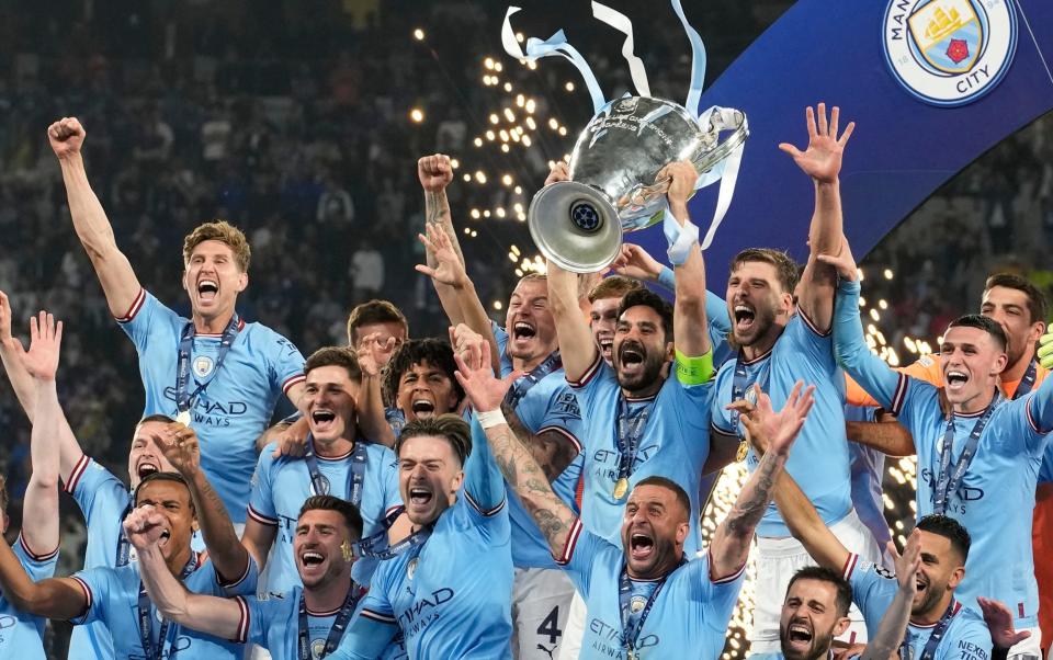 Manchester City players pose with the trophy after winning the Champions League final soccer match between Manchester City and Inter Milan at the Ataturk Olympic Stadium in Istanbul, Turkey, Sunday, June 11, 2023