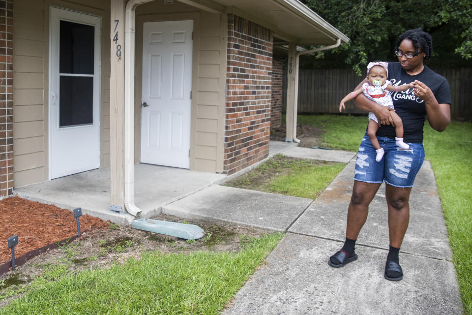 Tyesha Young, who lost her hospital job during the pandemic, holds her baby Jalayah Johnson outside their home in Waggaman, La., Friday, July 2, 2021. More than $7,000 behind on rent, Young had hoped a program in Louisiana would bail her out and allow her family to avert eviction in the coming weeks. But the 29-year-old mother of two from Jefferson Parish is still waiting to hear whether any of the $308 million available from the state for rental assistance and utility payments will give her a lifeline. She applied for money last year but never heard anything. ​(AP Photo/Sophia Germer)