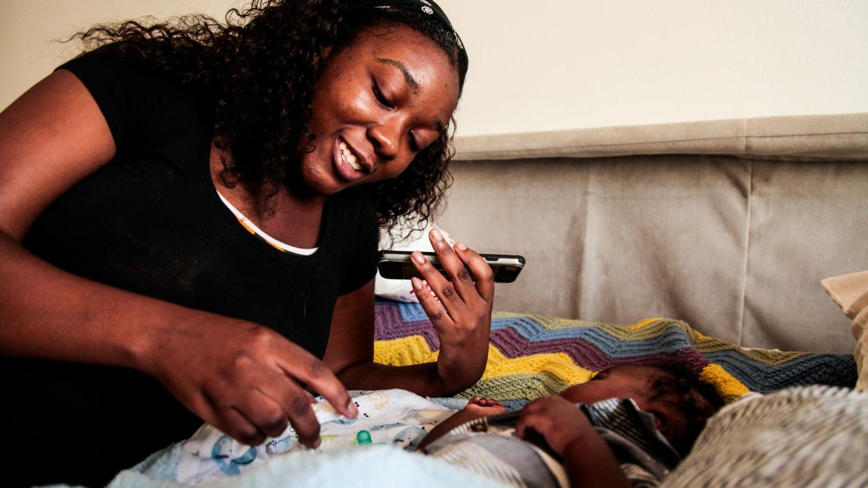 Natandra Lewis speaks to her mother on the phone who remains in Freeport, Grand Bahama. Lewis and her newborn Chandler escaped Hurricane Dorian's storm surge and are lucky to have clean water and restful nights in West Palm Beach Sept. 18, 2019 (Photo: Maria Alejandra Cardona for HuffPost)