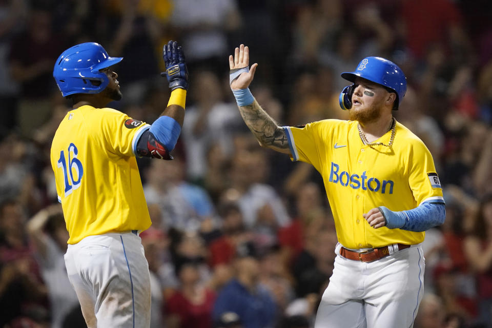 Boston Red Sox's Alex Verdugo, right, celebrates with Franchy Cordero (16) after scoring on an RBI-single by Christian Vazquez during the sixth inning of a baseball game against the Cleveland Guardians at Fenway Park, Monday, July 25, 2022, in Boston. (AP Photo/Charles Krupa)