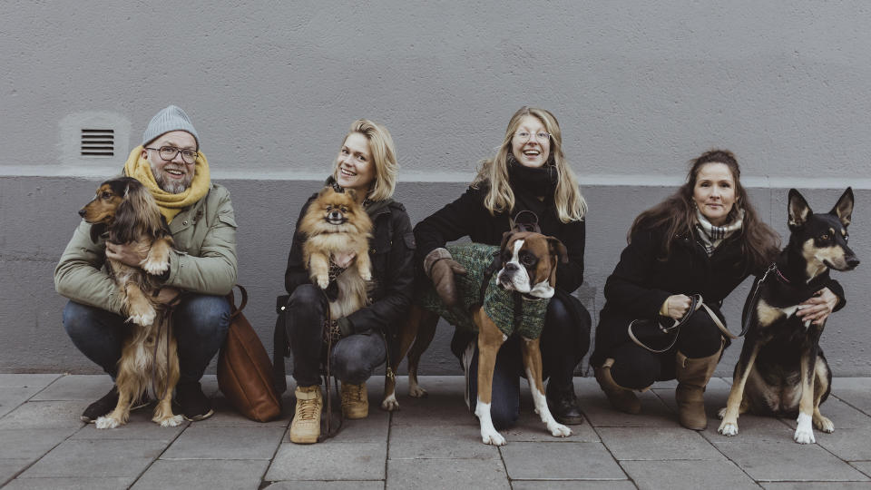 group of four people each with a dog