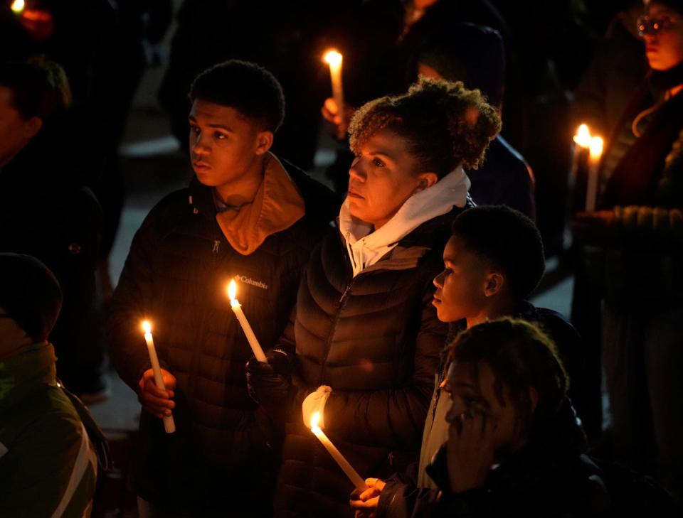 Patricia Poitevien of Barrington stands with her sons Noah LeBlanc, left, and Julien LeBlanc as they listen to speakers at Monday evening's candlelight vigil for Tyre Nichols.