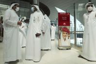 Emirati officials take part in a media tour presenting the new face and iris-recognition facilities at Dubai airport, United Arab Emirates, Sunday, March 7, 2021. Dubai's airport, the world’s busiest for international travel, has introduced an iris-scanner that verifies one’s identity and eliminates the need for any human interaction when leaving the country. (AP Photo/Kamran Jebreili)