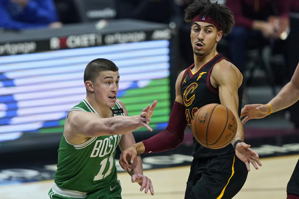 Boston Celtics' Payton Pritchard (11) passes the ball around Cleveland Cavaliers' Brodric Thomas (33) during the first half of an NBA basketball game Wednesday, May 12, 2021, in Cleveland. (AP Photo/Tony Dejak)