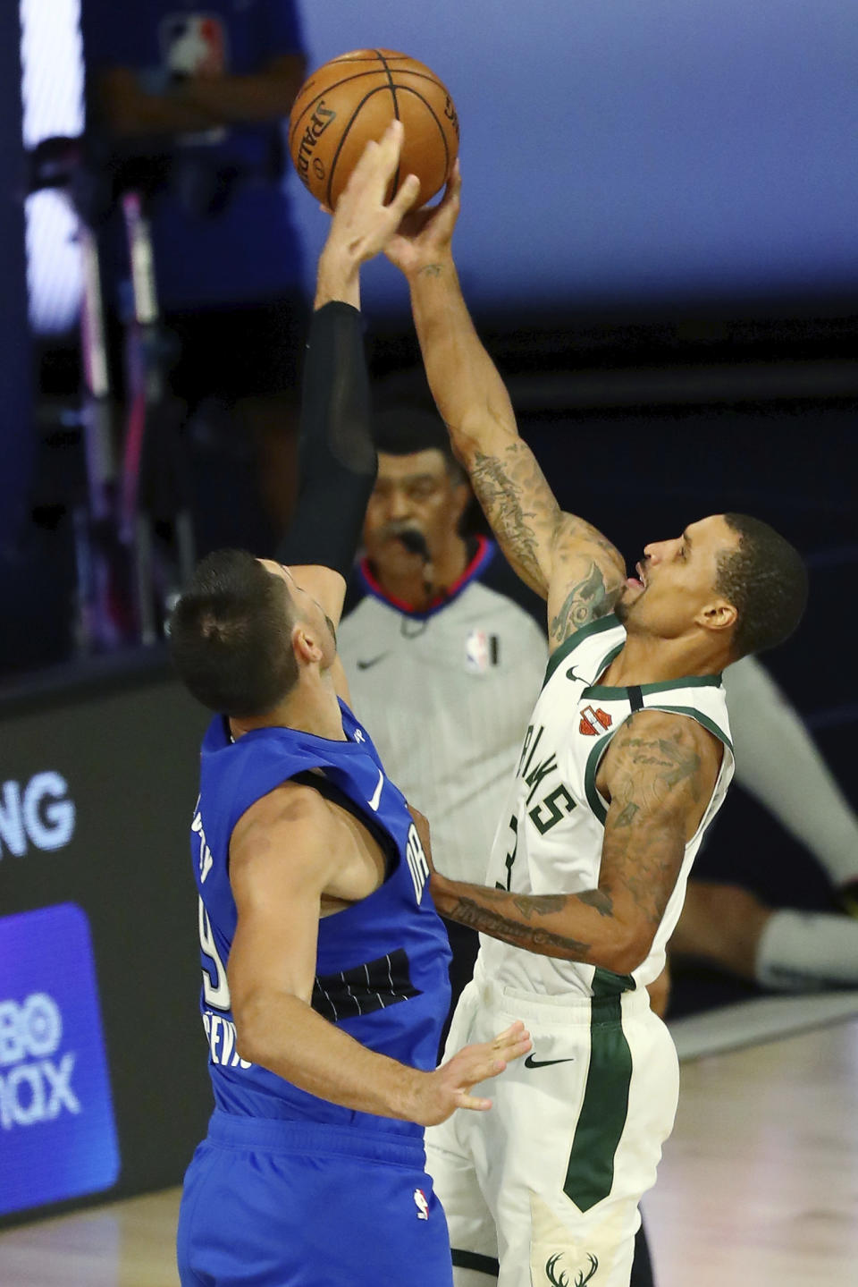 Milwaukee Bucks guard George Hill (3) shoots as Orlando Magic center Nikola Vucevic (9) defends during the second half of Game 1 of an NBA basketball first-round playoff series, Tuesday, Aug. 18, 2020, in Lake Buena Vista, Fla. (Kim Klement/Pool Photo via AP)