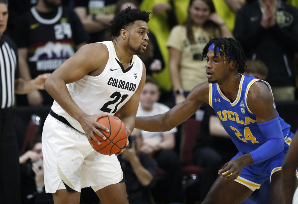 Colorado forward Evan Battey, left, looks to pass the ball as UCLA forward Jalen Hill defends in the first half of an NCAA college basketball game Saturday, Feb. 22, 2020, in Boulder, Colo. (AP Photo/David Zalubowski)