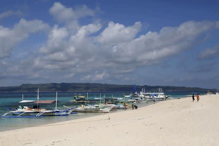 Traditional boats line up the shore in a secluded beach on the island of Boracay, central Philippines January 18, 2016. REUTERS/Charlie Saceda/Files