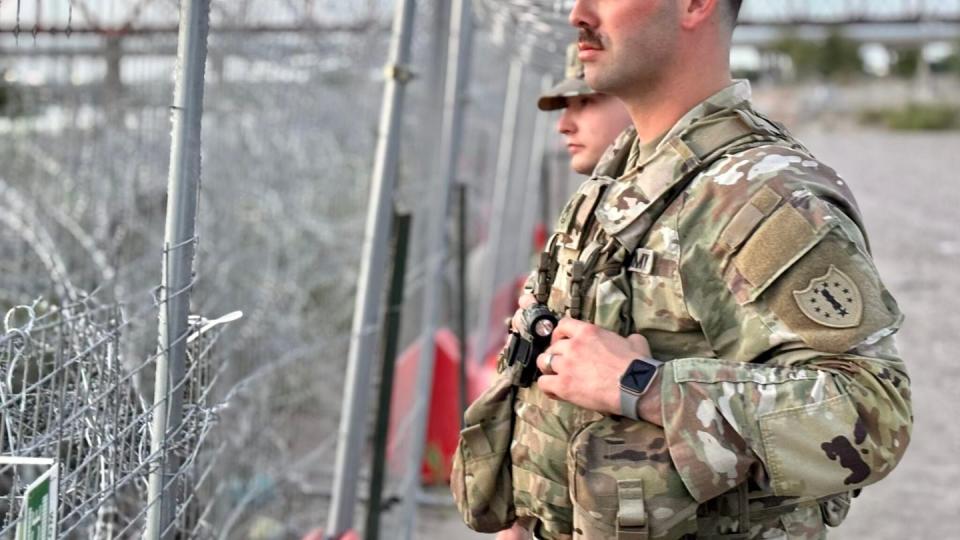 The 15 New Hampshire National Guard troops in Eagle Pass, Texas, are responsible for 1 1/2 miles of the border. Sgt. 1st Class Cameron Holt-Corti and Lt. Ryan Camp look across the Rio Grande, into Mexico. (Annmarie Timmins/New Hampshire Bulletin)