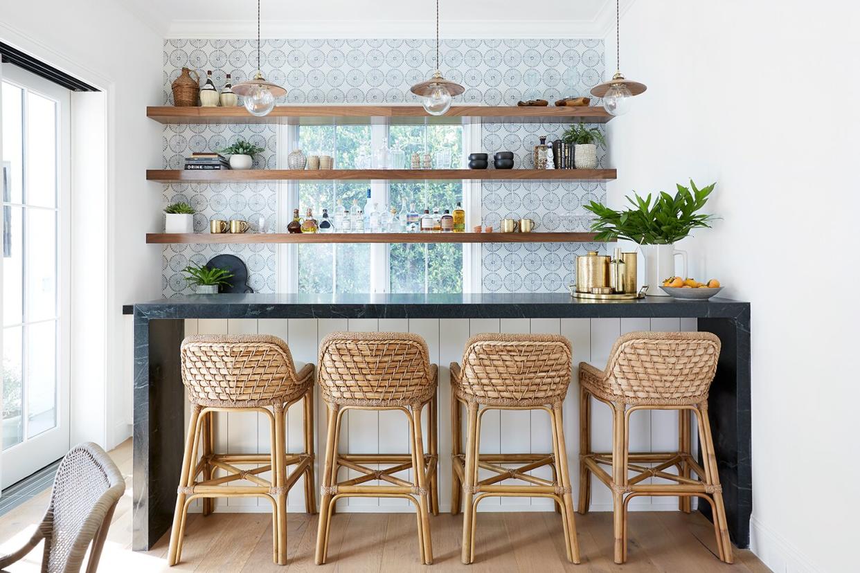 Home bar with woven stools, open shelving across window