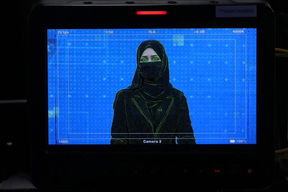 TV anchor Khatereh Ahmadi is seen on a studio monitor wearing a face covering as she reads the news on TOLO NEWS, in Kabul, Afghanistan, Sunday, May 22, 2022. Afghanistan's Taliban rulers have begun enforcing an order requiring all female TV news anchors in the country to cover their faces while on-air. The move Sunday is part of a hard-line shift drawing condemnation from rights activists. (AP Photo/Ebrahim Noroozi)