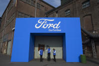 Hostesses wait for guests to arrive for a presentation of new models of Ford cars at SugarCity, an old sugar factory in Halfweg, near Amsterdam, Netherlands, Tuesday, April 2, 2019. At a glitzy unveiling of new cars with electric and hybrid engines, Ford of Europe Chairman Steven Armstrong warned of the potentially disastrous effects of a no-deal Brexit, in which the country leaves without a deal on future trade relations. That could mean tariffs and border checks that could seriously disrupt businesses, particularly the auto industry. (AP Photo/Peter Dejong)