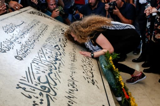 Ahed Tamimi kisses the tombstone of late Palestinian leader Yasser Arafat in Ramallah in the occupied West Bank, on July 29, 2018