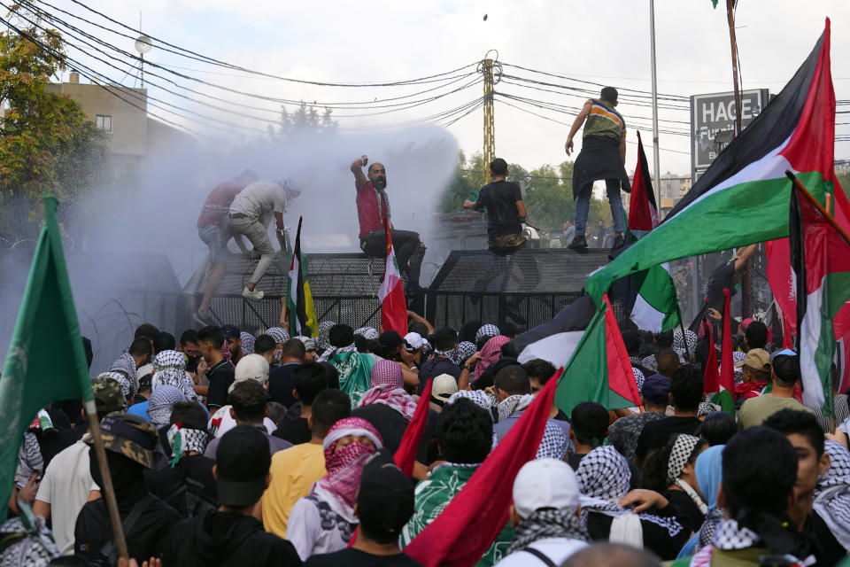 Riot police spray protesters with a water cannon during a demonstration in solidarity with the Palestinian people in Gaza, near the U.S. embassy in Aukar, a northern suburb of Beirut, Lebanon, Wednesday, Oct. 18, 2023. (AP Photo/Bilal Hussein)