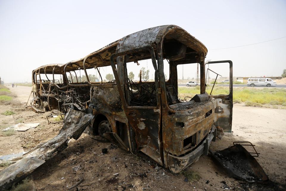 A view of a burnt bus in Taji, north of Baghdad July 24, 2014. A shooting and bombing attack on a bus near Baghdad killed 52 prisoners and nine policemen on Thursday, Ministry of Justice sources said, as politicians faced pressure to form a power-sharing government that can tackle a Sunni insurgency. The bus was transporting prisoners from a military base in the town of Taji to Baghdad when it was hit by roadside bombs, the sources said. Gunmen then opened fire. The attack left a burned shell of the vehicle along a rural road. (REUTERS/Thaier al-Sudani)