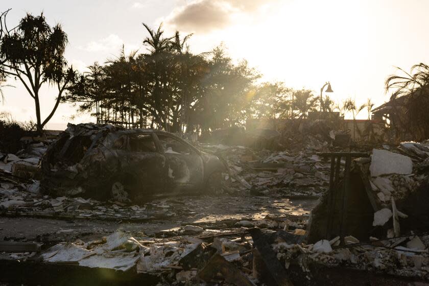 A burnt out car lies in the driveway of charred apartment complex in the aftermath of a wildfire in Lahaina, western Maui, Hawaii on August 12, 2023. Hawaii's Attorney General, Anne Lopez, said August 11, she was opening a probe into the handling of devastating wildfires that killed at least 80 people in the state this week, as criticism grows of the official response. The announcement and increased death toll came as residents of Lahaina were allowed back into the town for the first time. (Photo by Yuki IWAMURA / AFP) (Photo by YUKI IWAMURA/AFP via Getty Images)