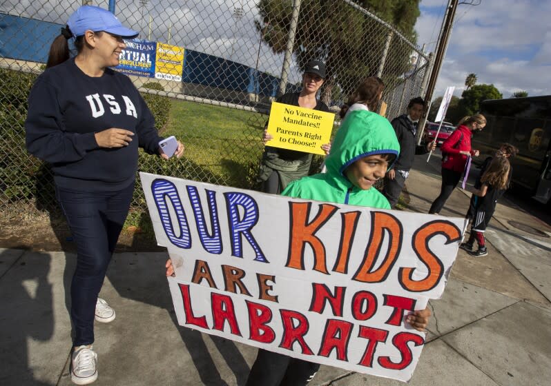 ENCINO, CA - October 18 2021: Parents and students from around the San Fernando Valley hold signs and shout as a protest against vaccine mandates in front of Birmingham High School on Monday, Oct. 18, 2021 in Encino, CA. (Brian van der Brug / Los Angeles Times)