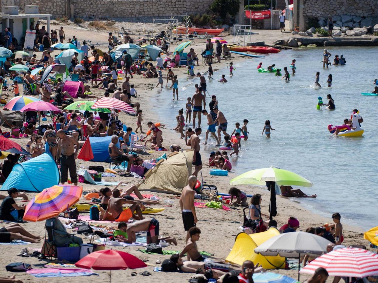 People enjoy the sea at the "Pointe Rouge" beach at the beginning of a heatwave in Marseille, southern France, 27 July 2020: Clement Mahoudeau/AFP via Getty Images