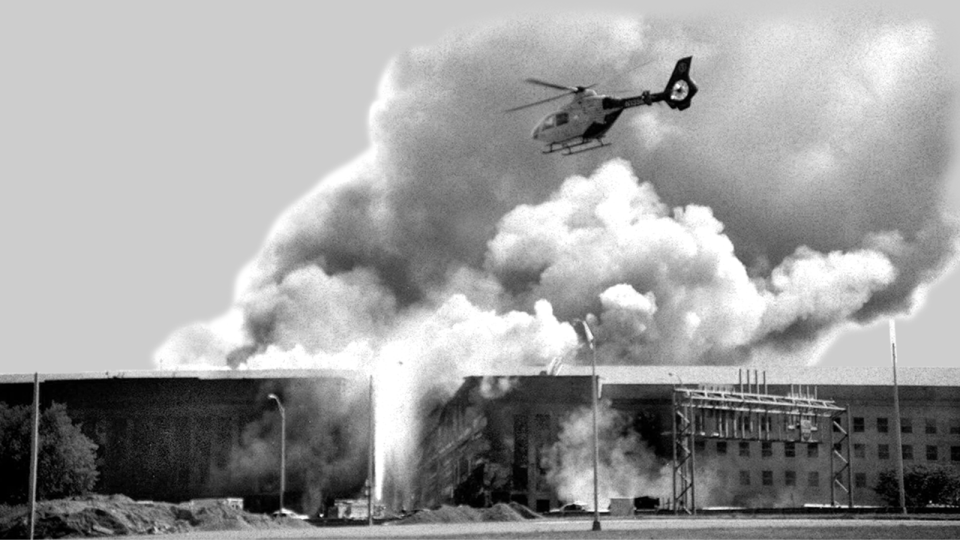 A helicopter flies over the Pentagon in Washington as smoke billows over the building, after being hit by Flight 77.