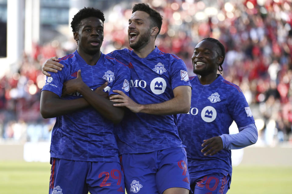 Toronto FC's Deandre Kerr, left, celebrates his goal against the Chicago Fire with Jesus Jimenez, middle, and Ayo Akinola during the first half of an MLS soccer match Saturday, May 28, 2022, in Toronto. (Jon Blacker/The Canadian Press via AP)