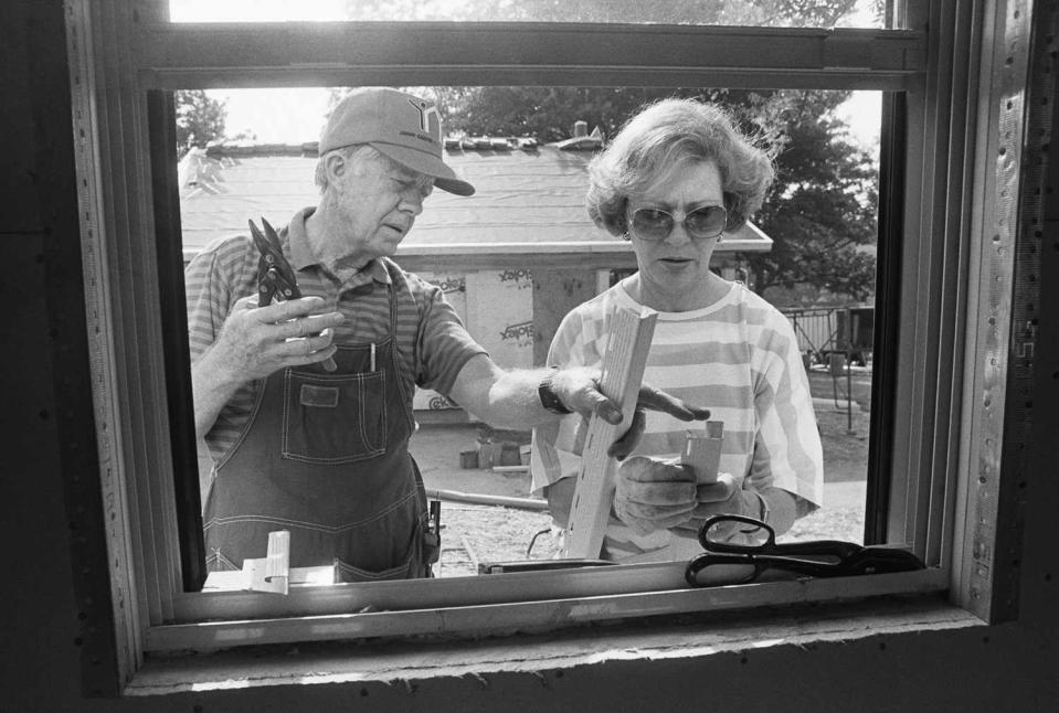 Former President Jimmy Carter and his wife Rosalynn work at a Habitat for Humanity site in Atlanta, building houses for working poor people.