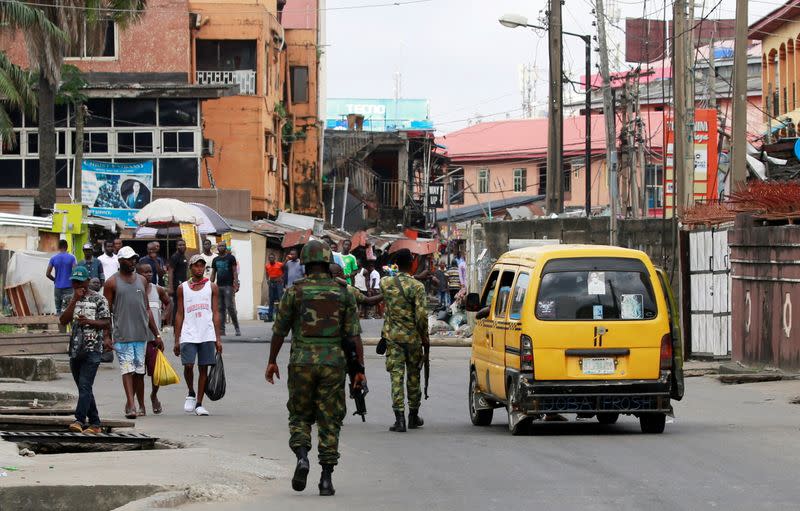 Military personnel walk along a street in Ikeja, in Lagos