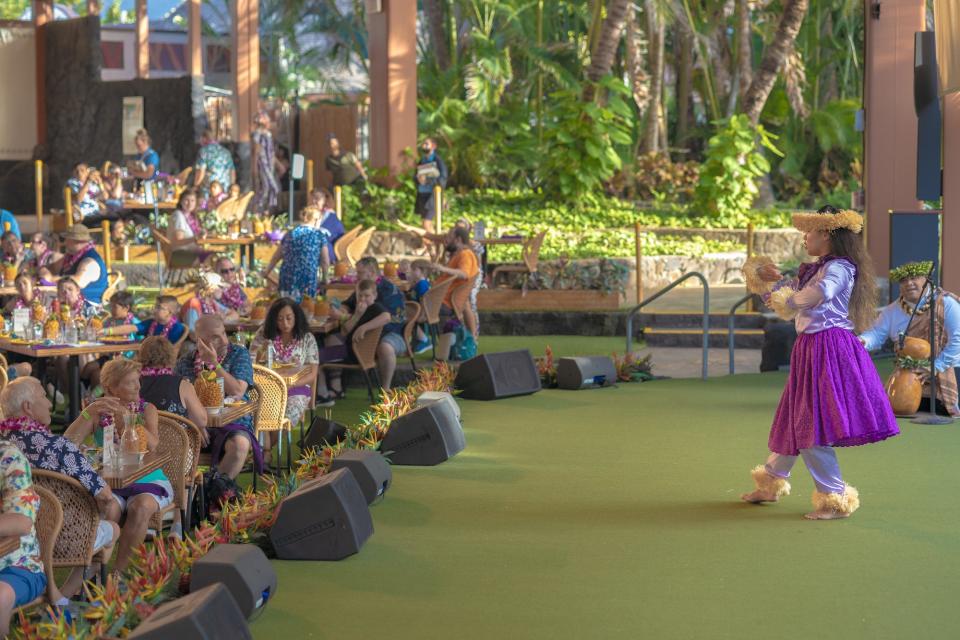 A female hula dancer expresses Queen Liliʻuokalani's story to the audience.