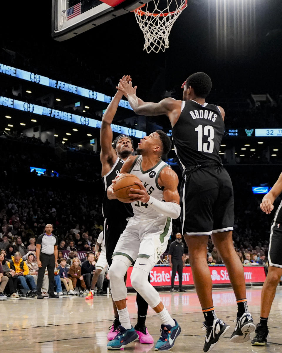 Milwaukee Bucks forward Giannis Antetokounmpo (34) is defended by Brooklyn Nets center Day'Ron Sharpe and guard Armoni Brooks (13) during the first half of an NBA basketball game in New York, Wednesday, Dec. 27, 2023. (AP Photo/Peter K. Afriyie)