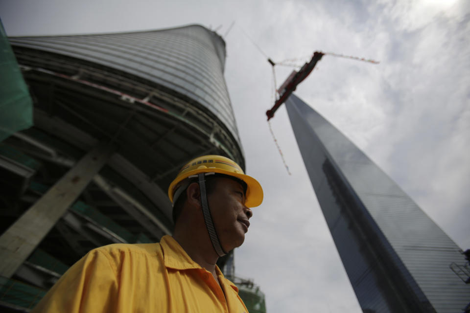 The last piece of the tower is lifted to put in place at the top of the Shanghai Tower during the topping off ceremony in Shanghai, China, Saturday, Aug. 3, 2013. The Shanghai Tower is set to become the tallest building in China which is planned to be complete in 2014. (AP Photo/Eugene Hoshiko)